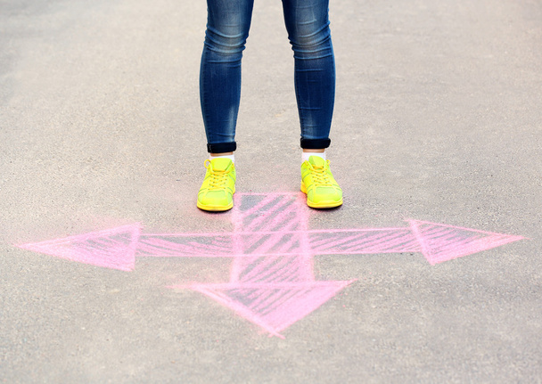 Female feet and drawing arrows on pavement background - Photo, Image