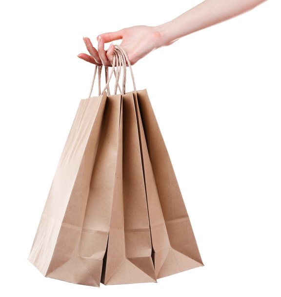 Female hand holding paper shopping bag isolated on white - Fotoğraf, Görsel