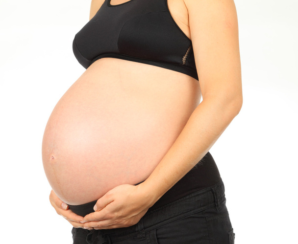 Young pregnant woman holds her belly - Foto, Bild
