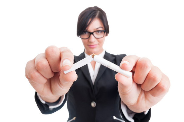 Business woman breaking a cigarette in half - Photo, Image