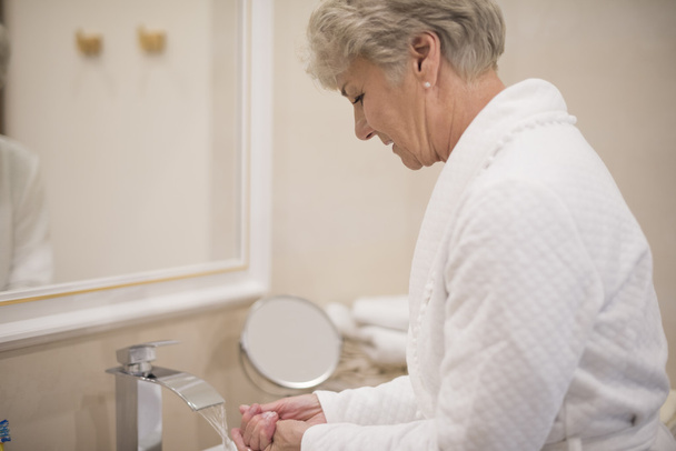 volwassen vrouw wassen van de handen - Foto, afbeelding