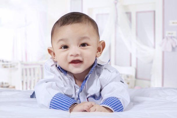 Sweet baby boy laughing on the bed - Foto, immagini