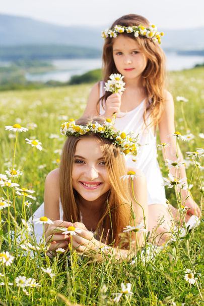 Two pretty girls at meadow with nice mountain view - Photo, Image