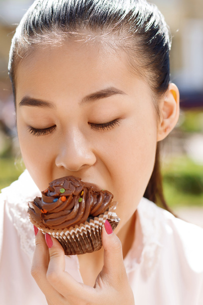 Close-up of woman with cupcake  - Valokuva, kuva