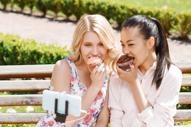 Two girlfriends doing selfie with cupcakes - Foto, Imagem