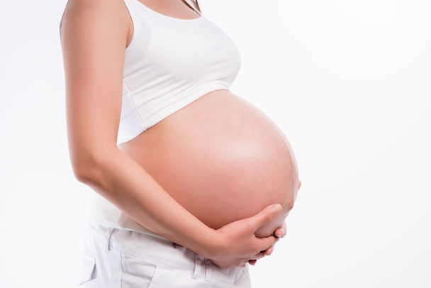 Pregnant woman holding ultrasound scan on her tummy - Foto, Imagem