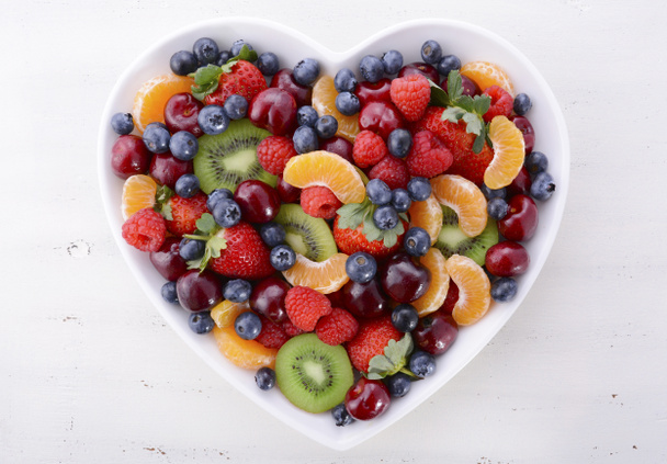 Colorful rainbow fruit in heart shape bowl. - Photo, Image