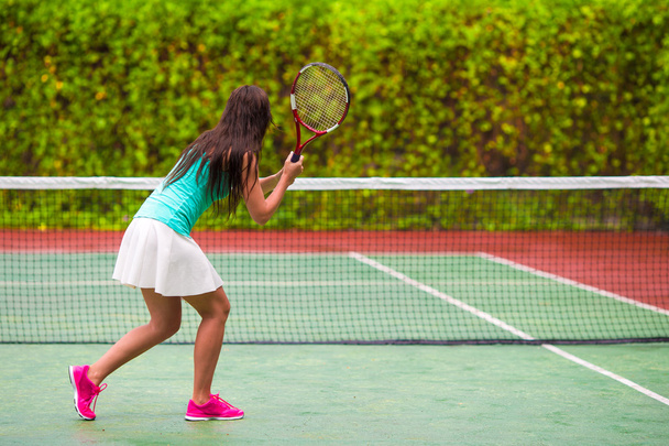 junge aktive Frau spielt im Tropenurlaub Tennis - Foto, Bild