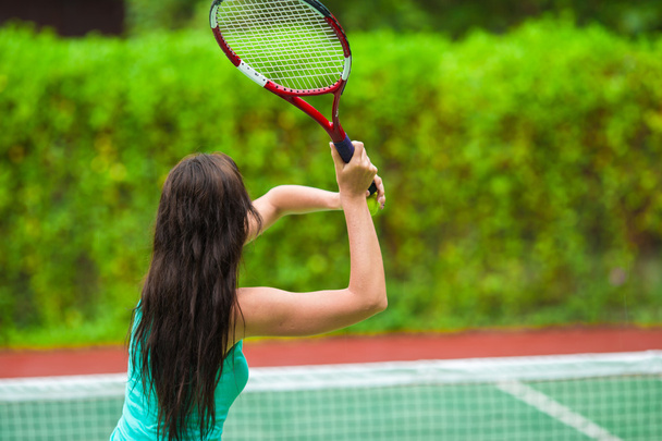 Joven mujer activa jugando al tenis en vacaciones tropicales
 - Foto, Imagen