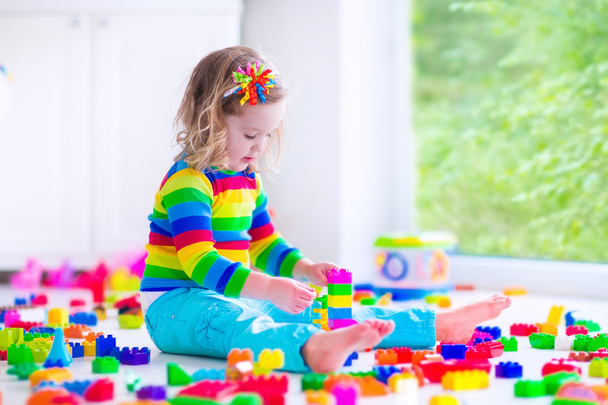 カラフルなおもちゃのブロックと遊ぶ少女 - 写真・画像