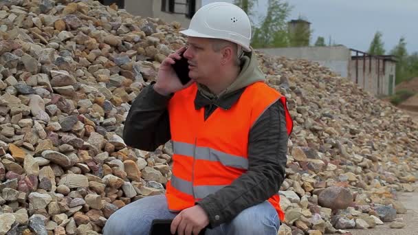 Επιθεωρητής κατασκευών με τηλέφωνο στο σωρό της θρυμματισμένου πέτρας - Πλάνα, βίντεο