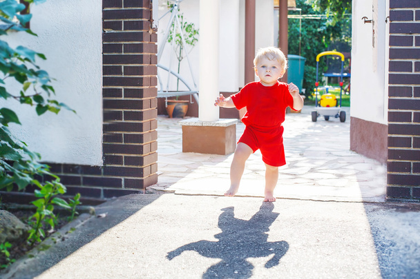little toddler baby boy making his first steps outdoors - Fotó, kép