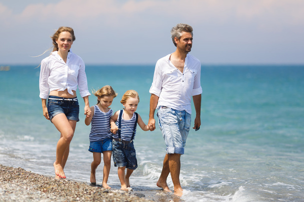 Família com dois filhos na praia
 - Foto, Imagem