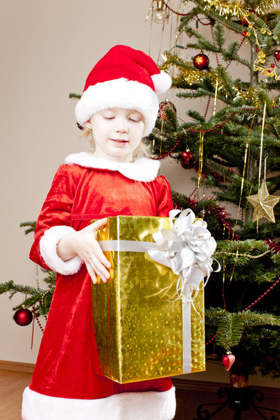 Little girl as Santa Claus with Christmas present - Фото, зображення