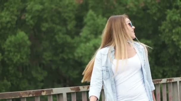 όμορφη κοπέλα φορώντας γυαλιά ηλίου περπάτημα - Πλάνα, βίντεο
