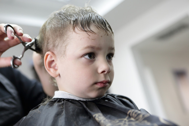 Barber cutting hair of a child - Foto, afbeelding