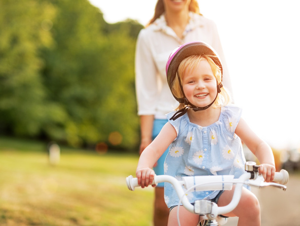 Smiling baby girl riding bicycle - Fotó, kép