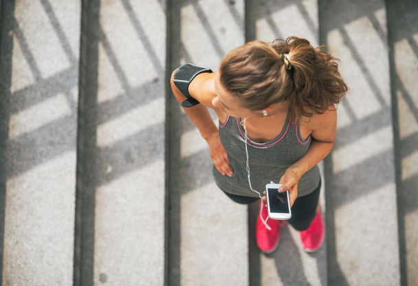 Portrait of fitness young woman with cell phone outdoors in the  - Photo, Image