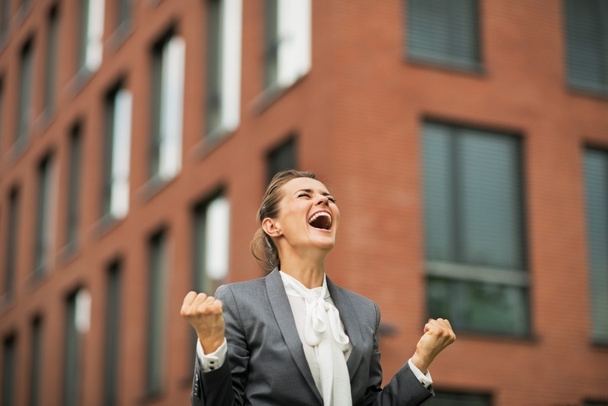 Happy business woman rejoicing in front of office building - Foto, afbeelding