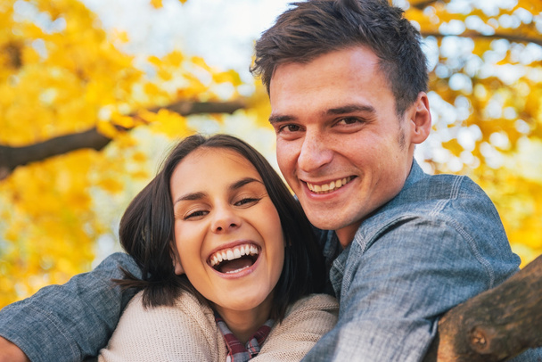 Портрет усміхненої молодої пари на відкритому повітрі восени
 - Фото, зображення