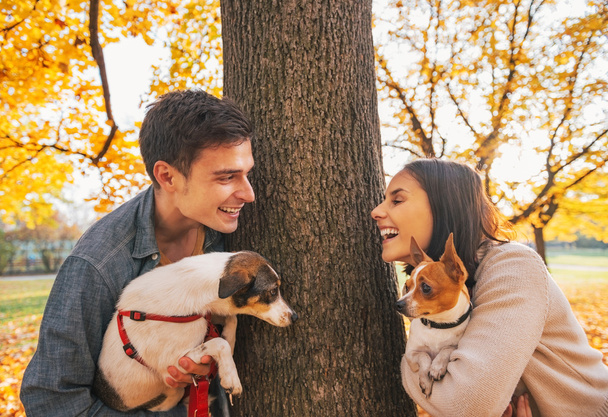 Portrait of happy young couple with dogs outdoors in autumn park - Fotografie, Obrázek