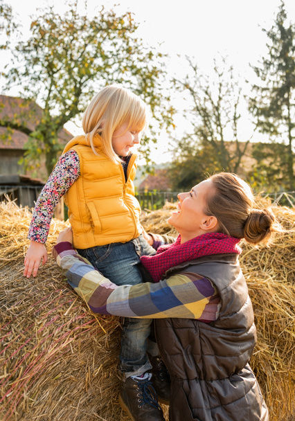 Happy mother and child sitting on haystack - Photo, Image