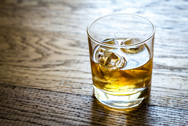 Glass of rum on the wooden background - Valokuva, kuva