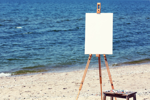 Easel with canvas on beach - Photo, Image