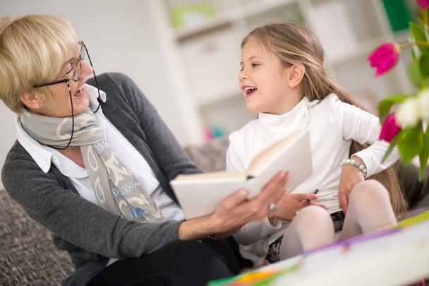 little girl with grandma reading interested book - Fotó, kép