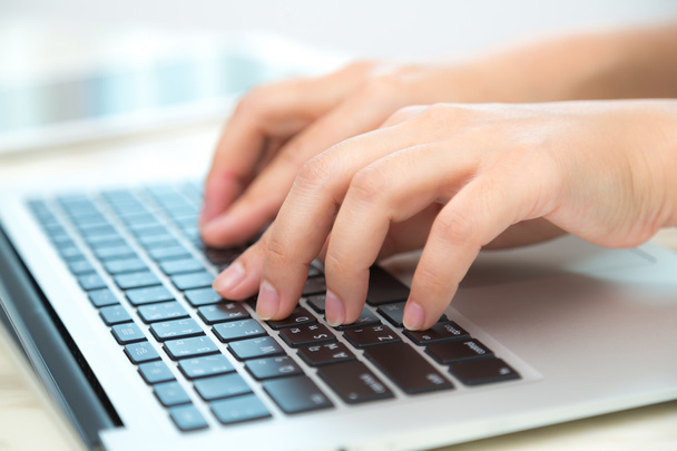 ノートパソコンのキーボードで入力するビジネス女性の手 - 写真・画像