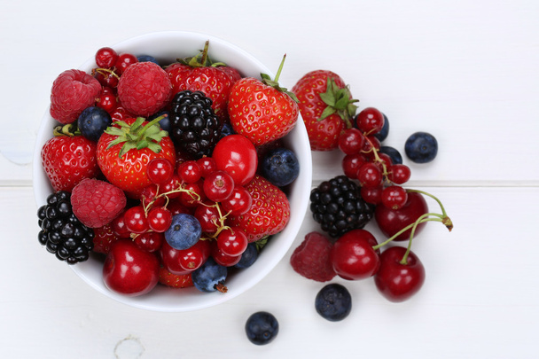 bessen vruchten mengen in kom met aardbeien, bosbessen en cher - Foto, afbeelding