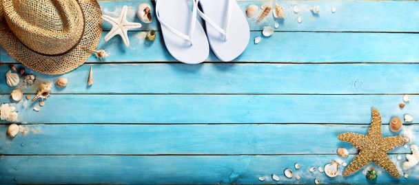 seashells on blue wooden plank with straw hat and flip-flop - Valokuva, kuva