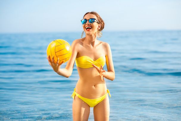 Mujer con bola amarilla en el mar
 - Foto, imagen