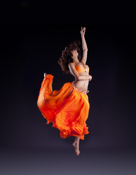 Beauty dancer jump in orange veil - arabian style - Foto, Imagen