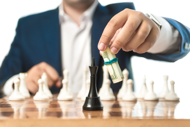 бизнесмен в костюме делает ход с долларами в шахматах
 - Фото, изображение