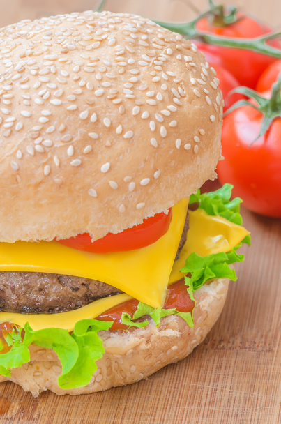 Νόστιμο cheeseburger με μαρούλι, βόειο κρέας, διπλό τυρί και κέτσαπ. Μακροεντολή με ρηχά εστίαση. - Φωτογραφία, εικόνα