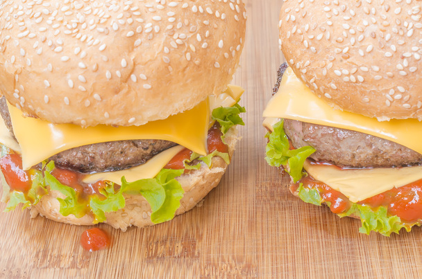 Dva chutné cheeseburgery s salát, hovězí maso, sýr a kečup. Mělké zaměření. - Fotografie, Obrázek