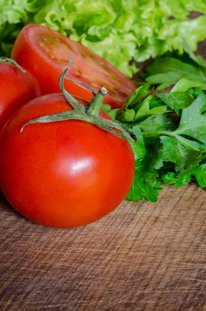 Mehukkaita tomaatteja vihreällä aineella puupöydällä
 - Valokuva, kuva