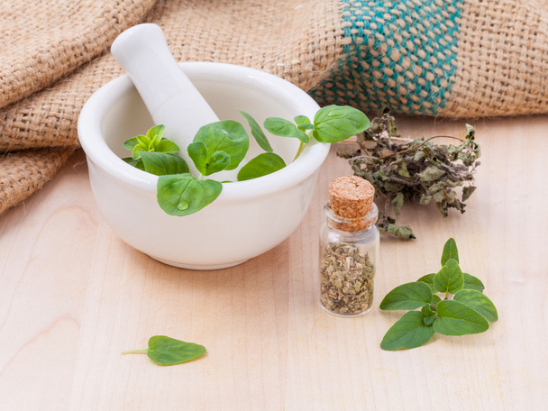Fresh oregano and dry with mortar on a wooden background. - Fotoğraf, Görsel