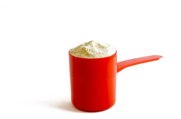 Colher isolada de proteína de soro de leite numa colher vermelha
 - Foto, Imagem