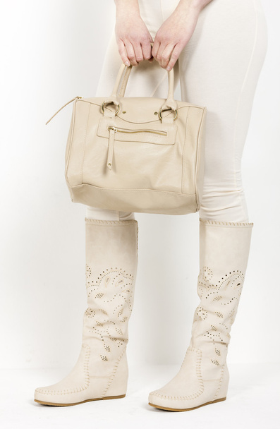 dettaglio di donna in piedi che indossa stivali estivi in possesso di una borsa
 - Foto, immagini