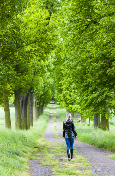 Nainen yllään kumisaappaat kävely kevätkujalla
 - Valokuva, kuva