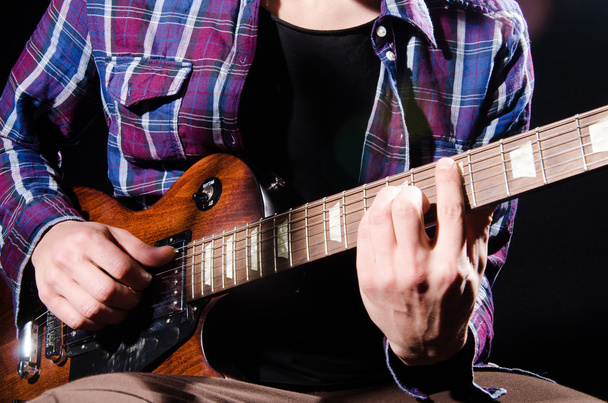 ember játszik a gitár, sötét szobában - Fotó, kép