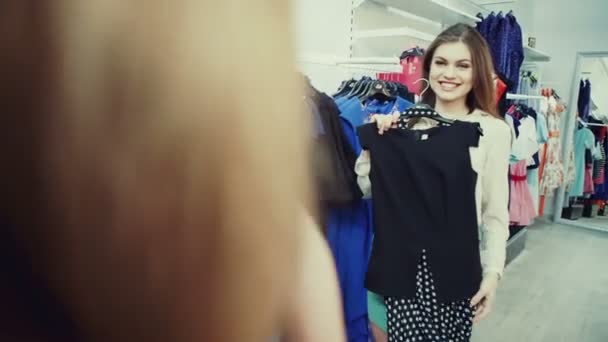 Fashion shopping -  Two happy young woman choose clothes in shop - Video