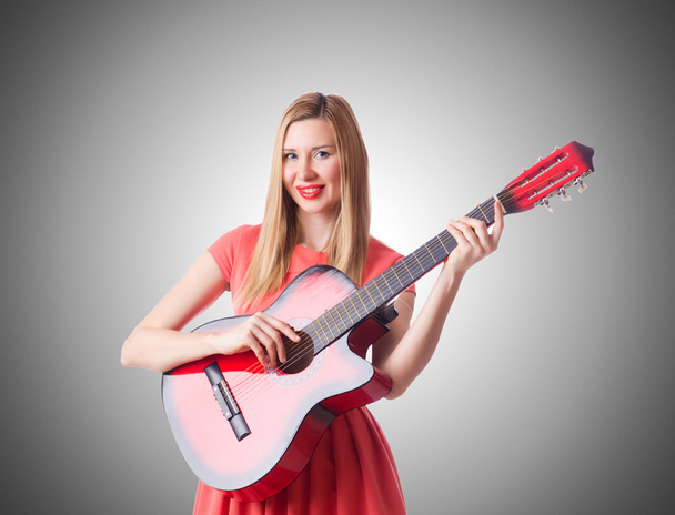 Woman playing guitar against the gradient  - Photo, Image