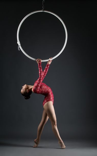 Studio shot of graceful acrobat performs with hoop - Foto, Imagen