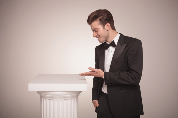 business man presenting something on a white column. - Photo, Image