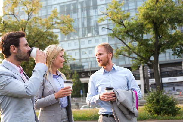 Businesspeople with disposable cups conversing - Φωτογραφία, εικόνα