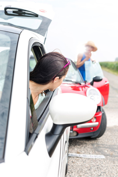 Mulher olhando para feminino batendo carro
 - Foto, Imagem