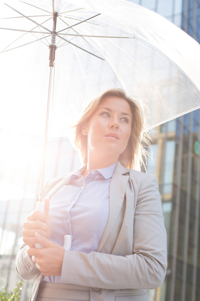 thoughtful businesswoman holding umbrella - Photo, Image